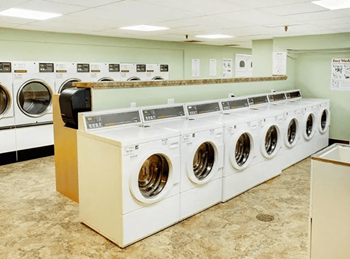 A row of white washing machines in a laundromat.